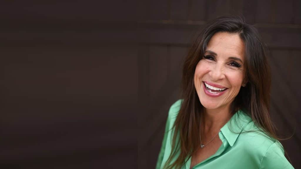 Tiffany Spelman, founder and CEO of FlowerHill Facility Services, smiling in a green blouse